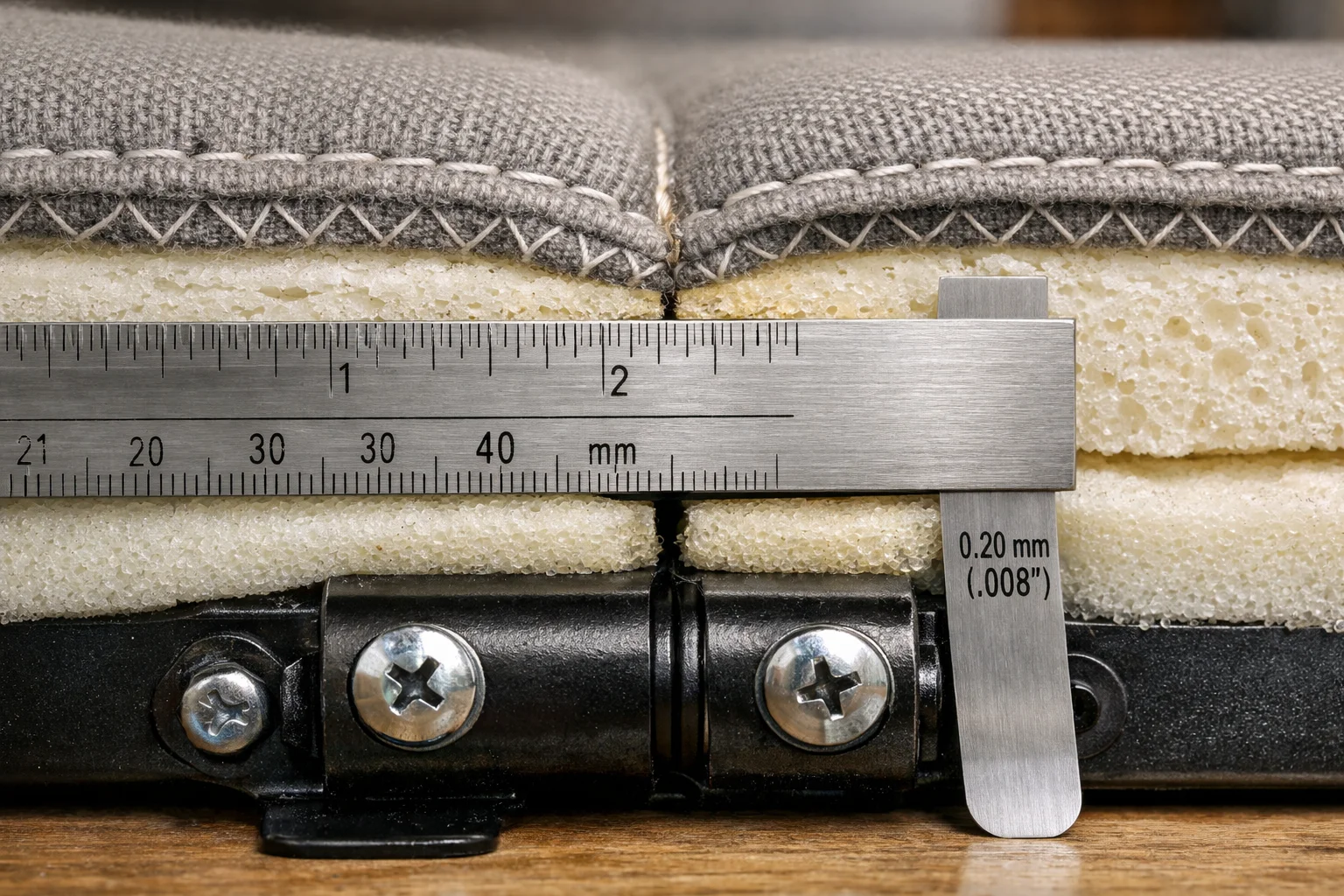 Cutaway of a fold-down sofa bed hinge line showing foam compression and a small step at the seam